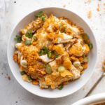 A steaming bowl of Buttery Old Bay Crab Mac and Cheese garnished with herbs and breadcrumbs.