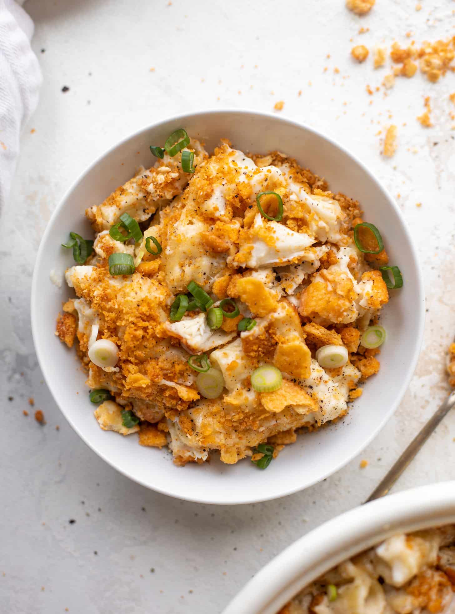 A steaming bowl of Buttery Old Bay Crab Mac and Cheese garnished with herbs and breadcrumbs.